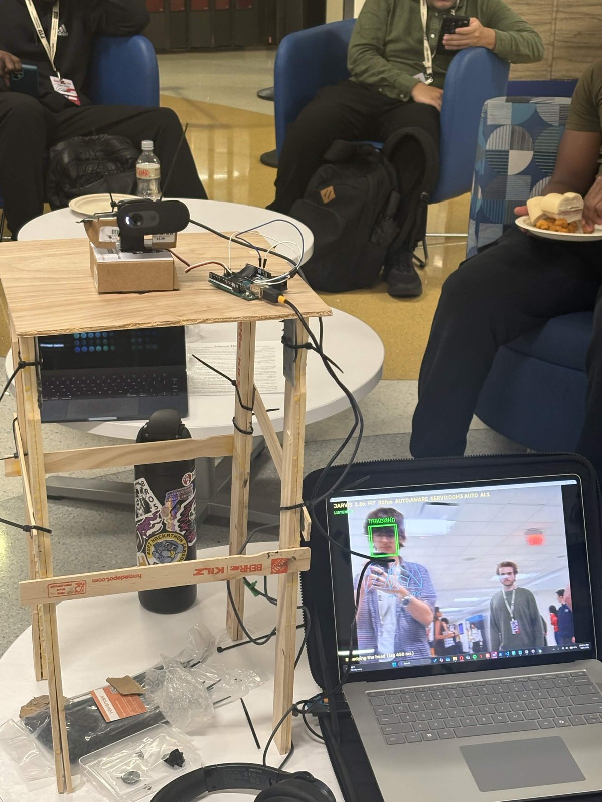 JARVIS on the table: a webcam on a servo head, an Arduino, and the laptop showing the tracking view